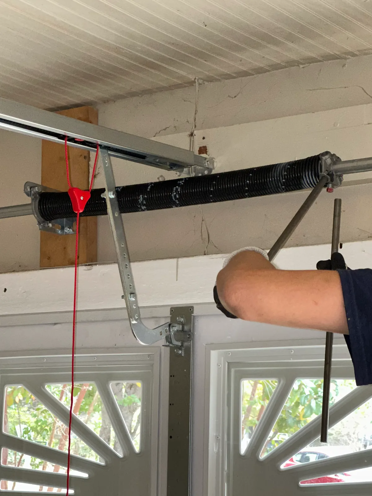 Technician working on a residential garage door spring